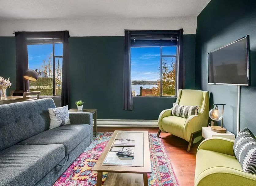 The Oxford at Pike Place Market, Seattle: lounge with sofa, armchairs, TV and windows with water view