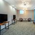 Home2 Suites by Hilton Florence lounge with sofa, chairs, TV and large blue-tinted windows