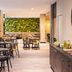 ibis Paris Alésia Montparnasse 14ème breakfast area in Paris with tables, chairs and a leafy wall