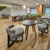 City Express Plus by Marriott Tijuana lounge with tables, chairs and shelving in a modern guest area