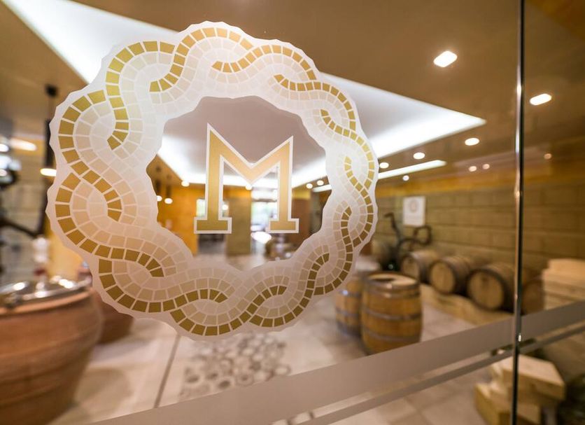 Resort & Winery Bosco De Medici in Pompei entrance with gold monogram on glass and wine barrels