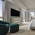 Four Seasons Hotel New Orleans guest room with city views, king bed, TV and teal chair