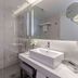 NH Monterrey La Fe bathroom with walk-in glass shower, floating sink vanity and mirror in Monterrey