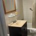 Buena Vista Inn Motel in Delhi bathroom with sink, mirror, shower curtain, and bathtub