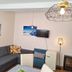 Dorf.Apart in Neustift im Stubaital living area with sectional sofa, wall TV, fireplace and lamp