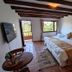 Casa de Campo Hotel & Spa, Villa de Leyva: rustic room with king bed, exposed beams, balcony and garden view