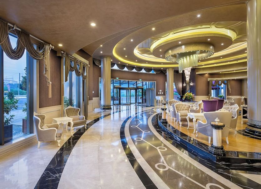 Limak Eurasia Luxury Hotel in Istanbul lobby with curved marble floors, chandelier ceiling, and glass entrance