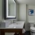 Four Points by Sheraton Brunswick bathroom with vanity, toilet, shower-tub combo and wall art