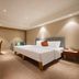 Wanhao International Hotel Benxi guest room with king bed, desk, TV, and neutral decor