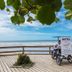 Hotel Itapema Meia Praia beach view with tricycle signboard on wooden deck in Itapema