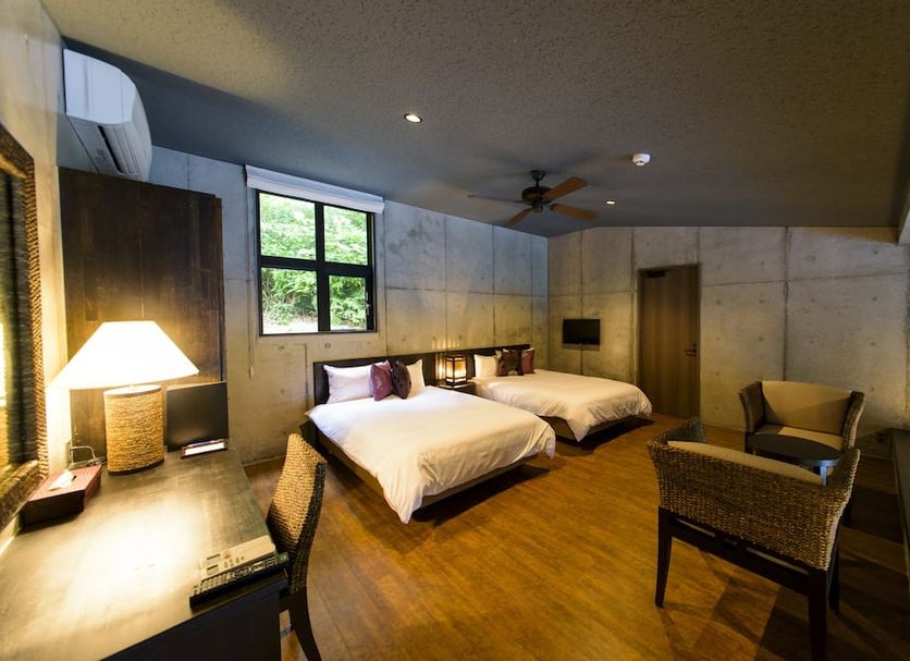 Magachabaru Okinawa guest room in Nakijin with two beds, wood flooring, and sitting area
