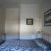 Trafalgar Lodge Nelson guest room with patterned bed, framed wall art, and white headboard