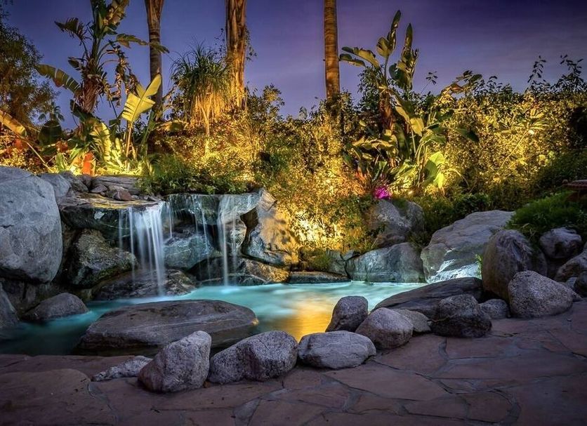 Vista Grande Resort Palm Springs waterfall pool with rocks and tropical landscaping at dusk