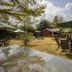 Balis Best Bar and Resort Nairobi garden seating area with umbrellas and a red cottage
