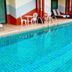 Mei Zhou Phuket Hotel in Phuket City indoor pool with lounge chairs and white patio seating