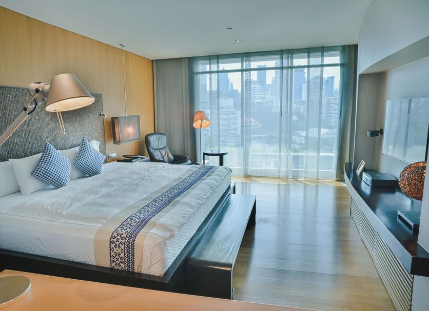 Tui Blue Maduzi Hotel Bangkok room with king bed, floor-to-ceiling city view windows and lounge chair