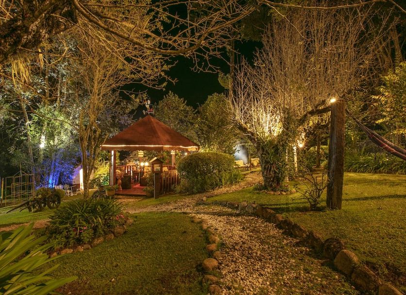 Pousada das Hortensias in Campos do Jordão: garden path leading to a lit gazebo at night