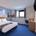 Travelodge Hull Central room with double bed, desk, wall-mounted TV and window in Hull