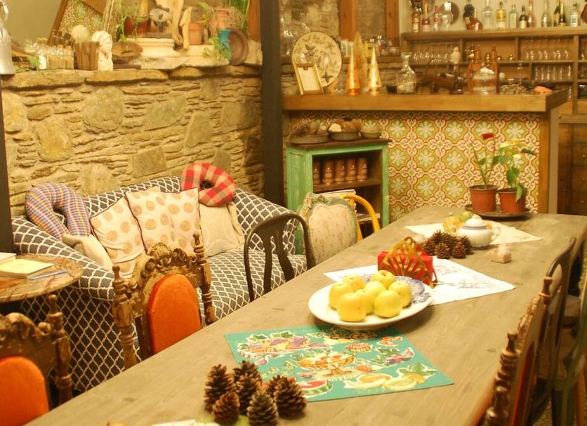 Ibri Hotel, Selçuk: rustic lounge with stone wall, wicker chairs and long dining table with fruit