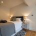 Winchelsea Lodge bedroom with king bed, bedside lamps and a view into the hallway in Winchelsea