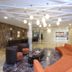 Howard Johnson by Wyndham Barranquilla Versalles lobby with curved orange seating, pendant lights, and marble floor