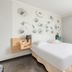 Appart'City Classic Reims Parc des Expositions room with double bed, floral wall art and sheer curtains