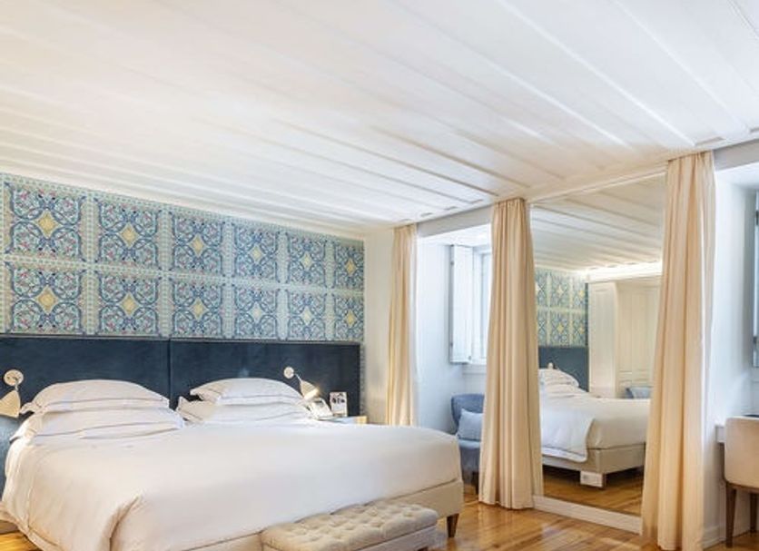 Santiago de Alfama - Boutique Hotel bedroom in Lisbon with king bed, mirrored wall and wood floors