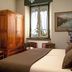 Villa Ucci in Onno guest room with bed, wooden armoire, chairs, window and framed wall art