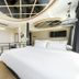 Jk Hotel Busan guest room with white bed, loft-style ceiling detail and wall-mounted TV