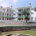 Himgiri Resorts in Dharamshala, white hillside hotel with balconies and landscaped lawn