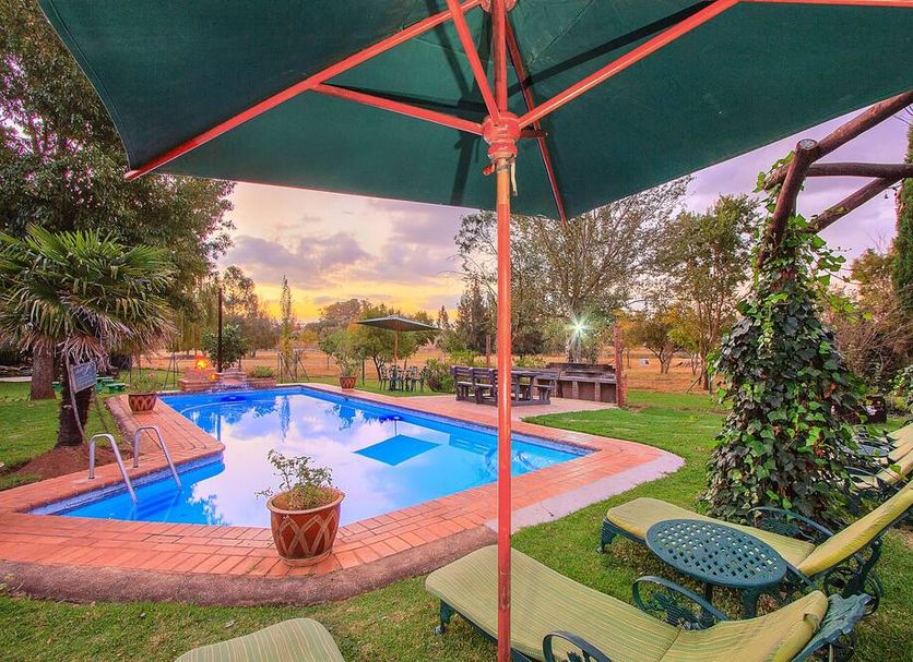 Airport Bird & Game Lodge in Kempton Park with a pool, garden seating, and sunset view