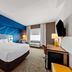 Comfort Inn & Suites Donna guest room with king bed, desk, wall-mounted TV, and modern blue accent wall