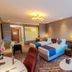 Vip Hotel Doha guest room with two twin beds, seating area, and chandelier lighting