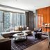 The St. Regis Hong Kong suite with city views, orange accent wall, sofa and coffee table