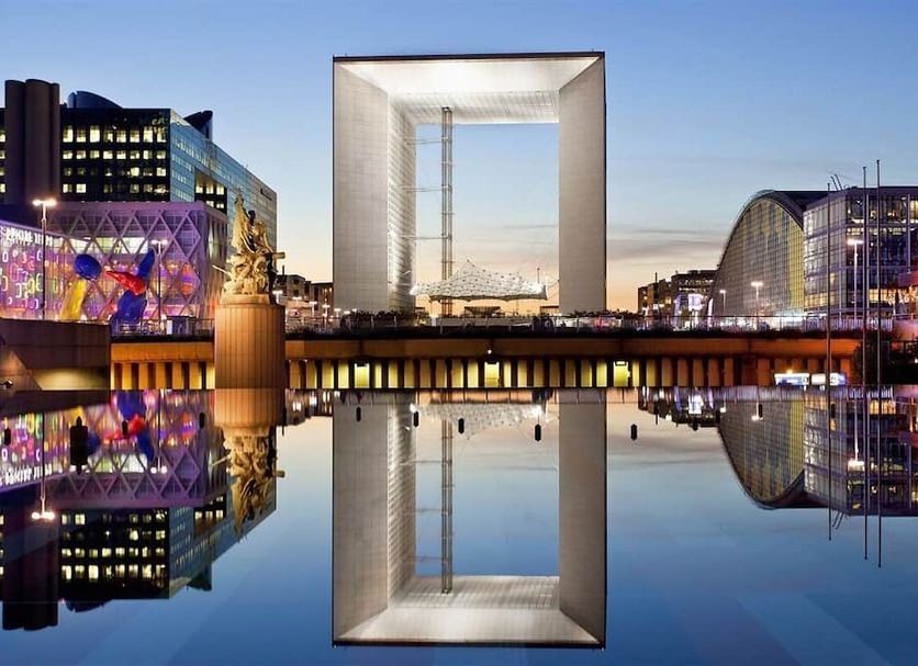 Aparthotel Adagio la Défense Courbevoie with reflective water view and illuminated La Défense skyline