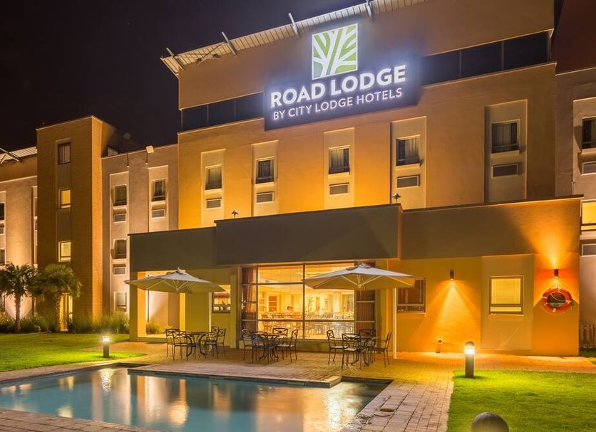 Road Lodge Bloemfontein Airport exterior at night with pool and patio in Bloemfontein