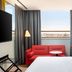 Hyatt Place London City East room with red sofa, desk, and city view in London