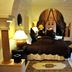 Riad Al Mendili Private Resort & Spa in Marrakech, a cozy bedroom with draped canopy bed and patio doors