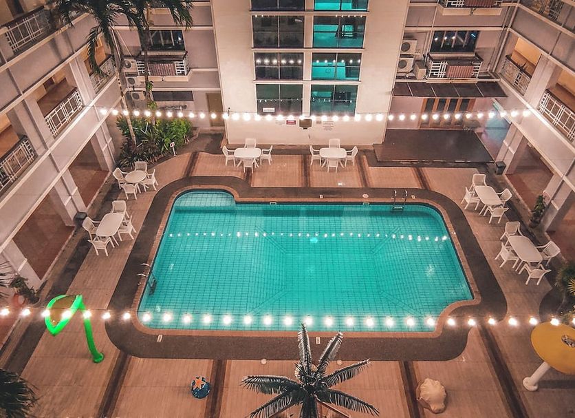Starlodge Jerudong courtyard pool with string lights and surrounding balconies