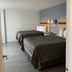 Arya Blu Inn and Suites in Ormond Beach guest room with two double beds and bedside lamps