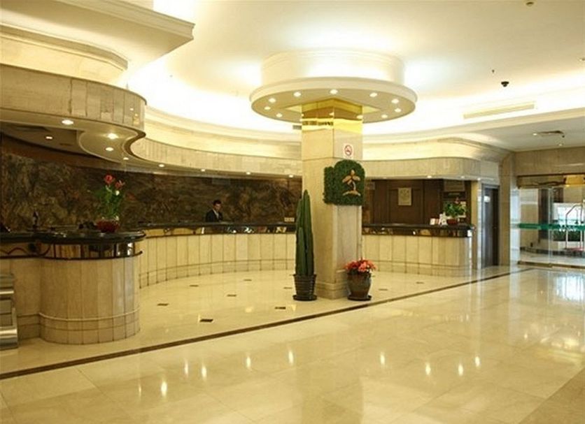 Oasis Tower Shanghai hotel lobby with marble reception desks and polished floor