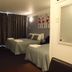 Raceway Motel Whanganui room with two single beds, curtains, desk and wall art