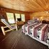 The Lodge at Lolo Hot Springs room with two beds, wood-paneled walls and a mountain-view window in Lolo