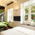 Kruisherenhotel Maastricht guest room with green sofa, large artwork and tall windows