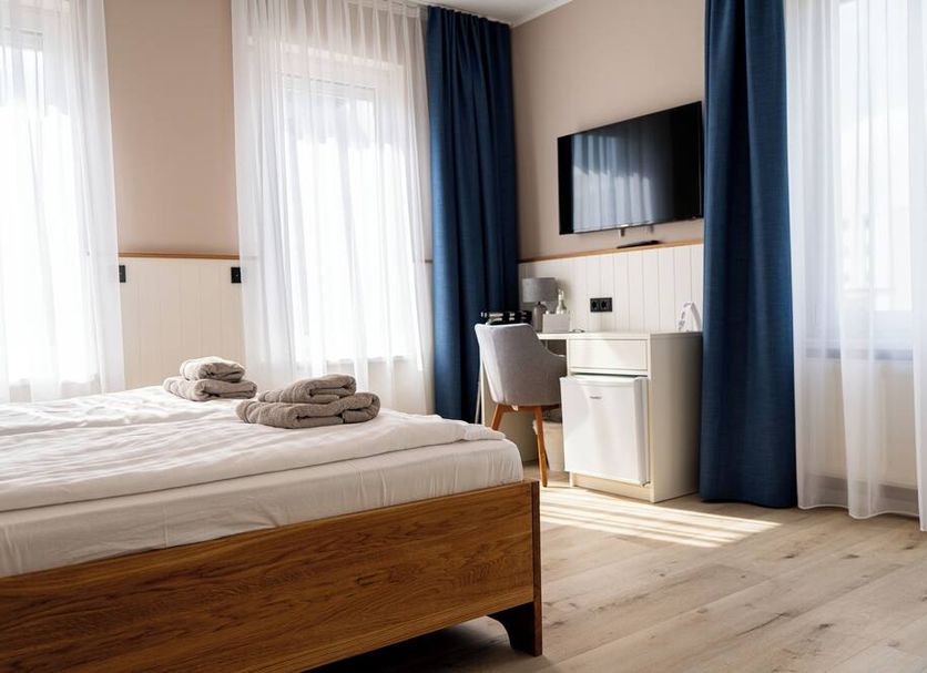 Hotel Seebrise Grömitz room with bed, desk, TV, and large windows in Grömitz