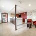 OYO Hotel Mcallen Airport South lobby in McAllen with red chairs, reception desk and stone accent wall