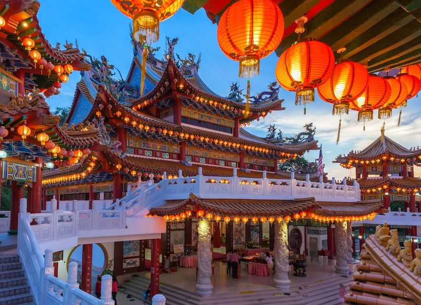 Intercontinental Hotels Kuala Lumpur By IHG with illuminated Chinese-style temple architecture at dusk