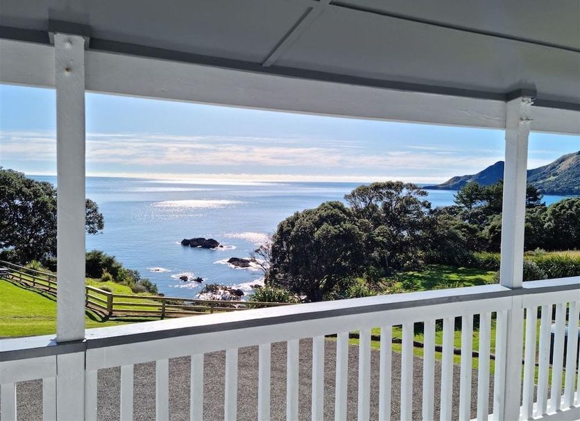Lottin Point Motel in Hicks Bay with a covered porch overlooking the ocean and coastal hills