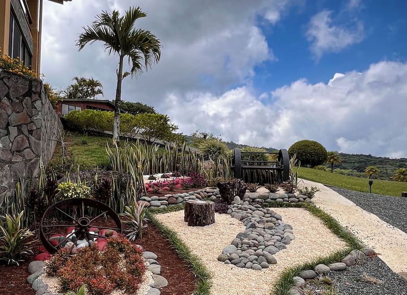 Hotel Montaña Monteverde in Santa Elena with landscaped garden, stone pathways, palm trees and mountain views