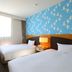 Koko Hotel Tomakomai guest room with two twin beds, chair, and large window in Tomakomai